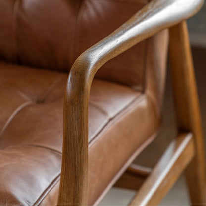 Vintage brown leather armchair with button-tufted backrest
